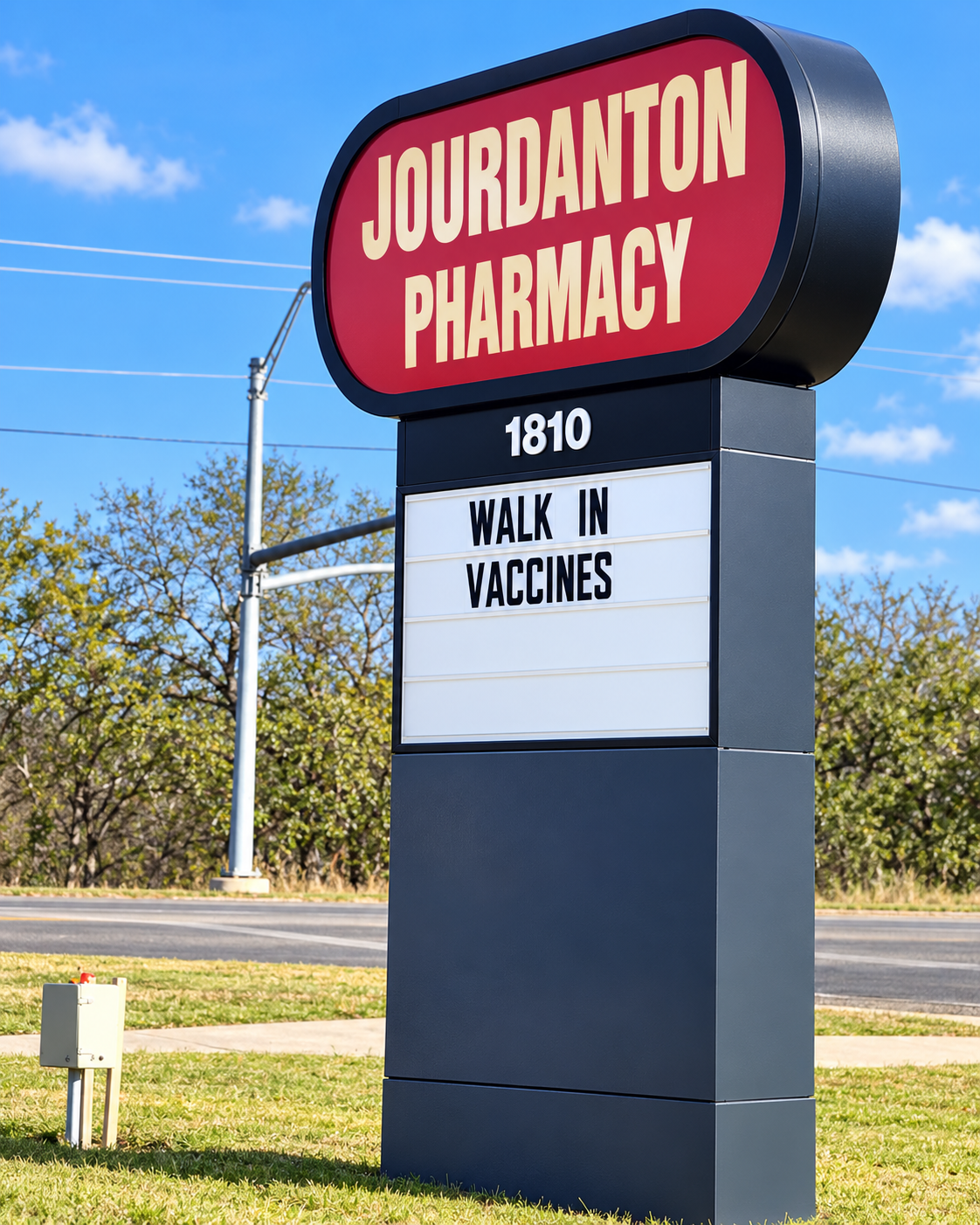 Jourdanton Pharmacy roadside sign showing 1810 and Walk In Vaccines